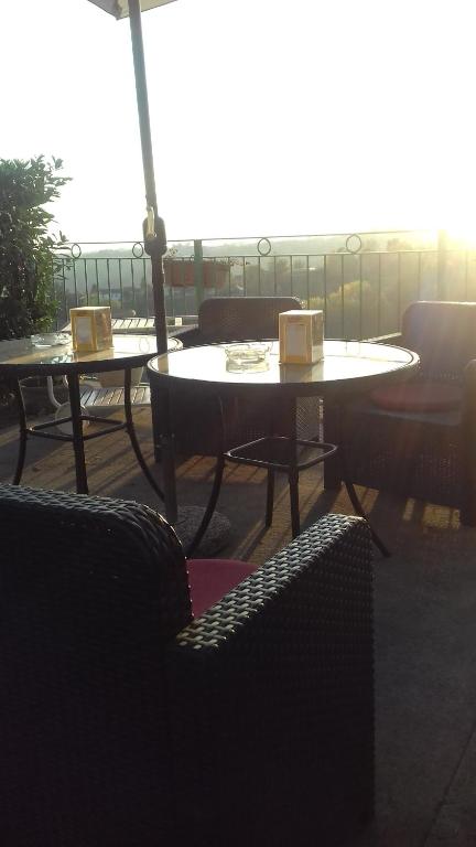due tavoli e sedie con ombrelloni su un patio di La Terrazza ad Asti