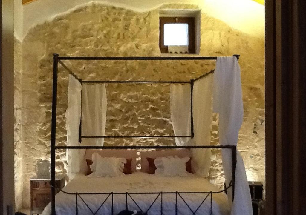 sypialnia z łóżkiem w kamiennej ścianie w obiekcie Borgo in corte w mieście Martano