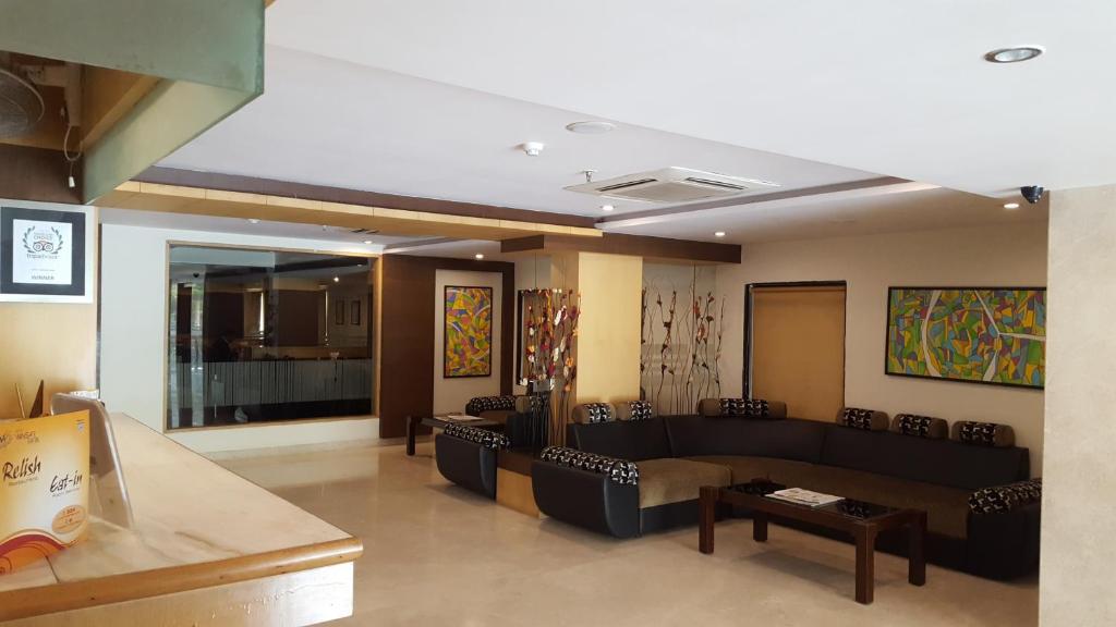 uma sala de estar com sofás e mesas num quarto em Hotel Winsar Park em Visakhapatnam