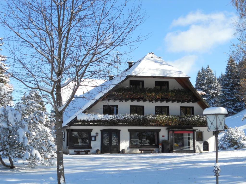 a white house with snow on the roof at Gästehaus Behabühl in Feldberg