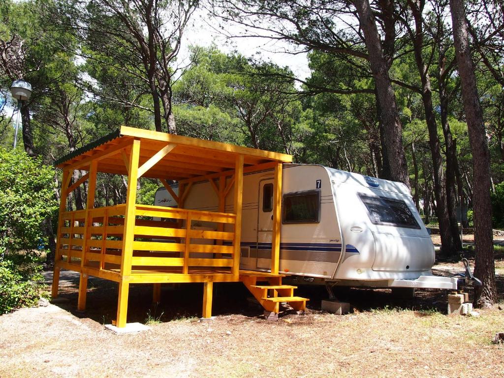 un wagon garé dans un champ à structure en bois dans l'établissement Caravans Baško Polje, à Baška Voda