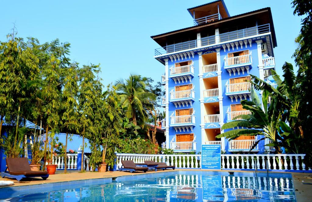 un hotel con piscina di fronte a un edificio di Mayflower Beach Resort a Baga