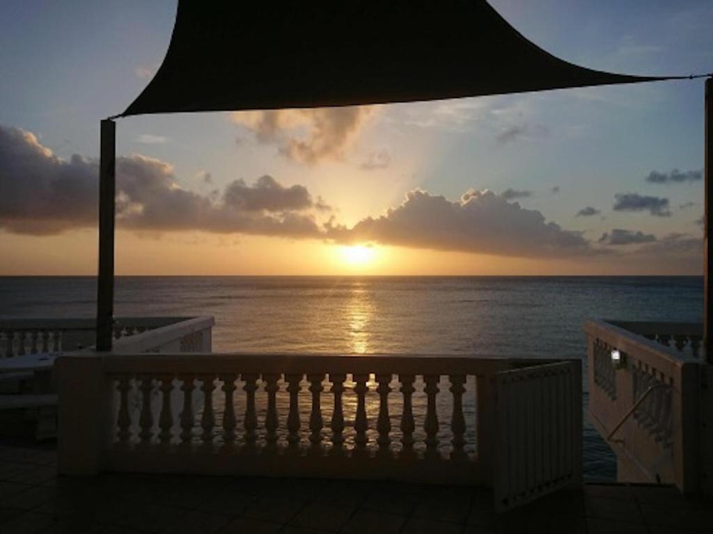 a sunset over the ocean from a balcony at My Dream Apartments in Lagun