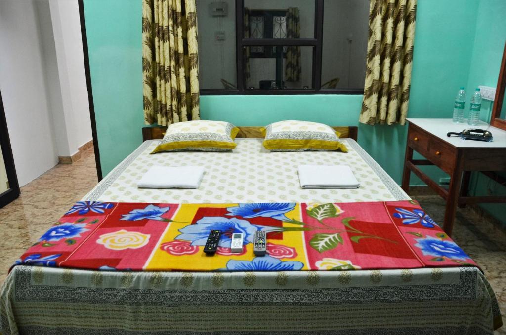 a bed with a colorful quilt on top of it at The Lotus Home in Port Blair
