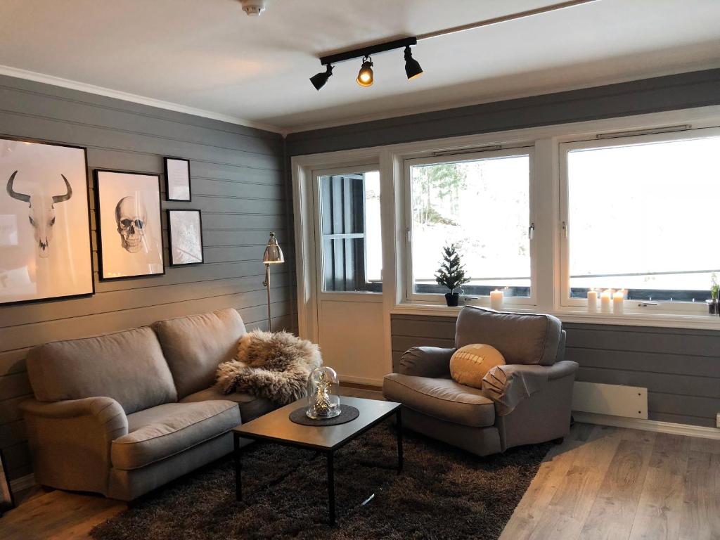 a living room with a couch and chairs and a window at Storehorn Apartments in Hemsedal