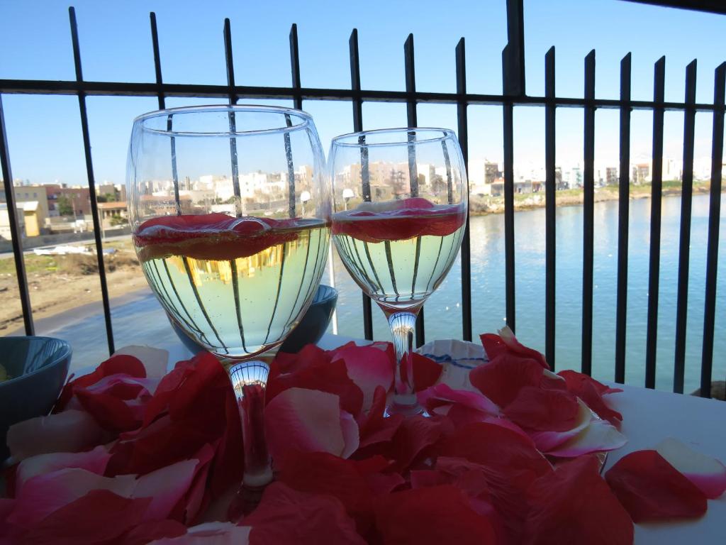 - deux verres de vin assis sur une table avec des fleurs dans l'établissement Il Mare do Zu Pippo, à Augusta