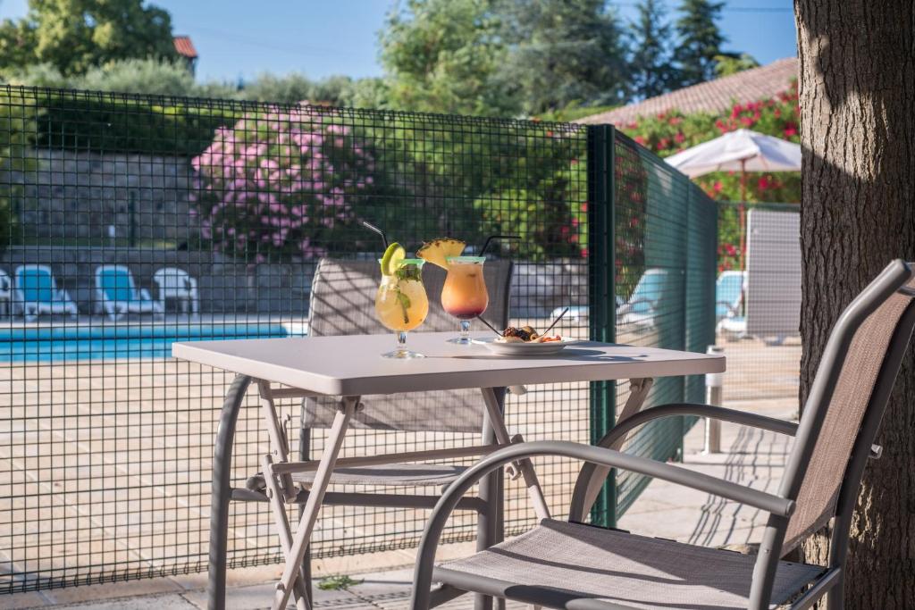 a white table with two drinks on top of it at Le Clos des Bruyères in Vallon-Pont-dʼArc