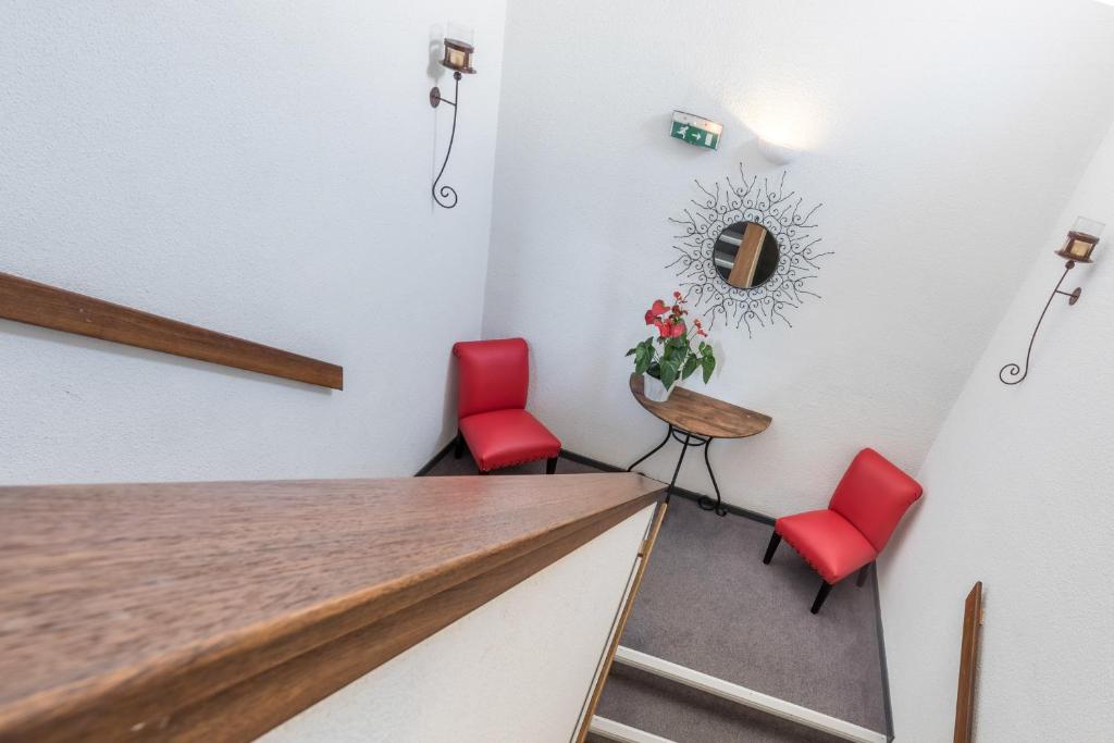 a room with two red chairs and a table at Le Clos des Bruyères in Vallon-Pont-dʼArc