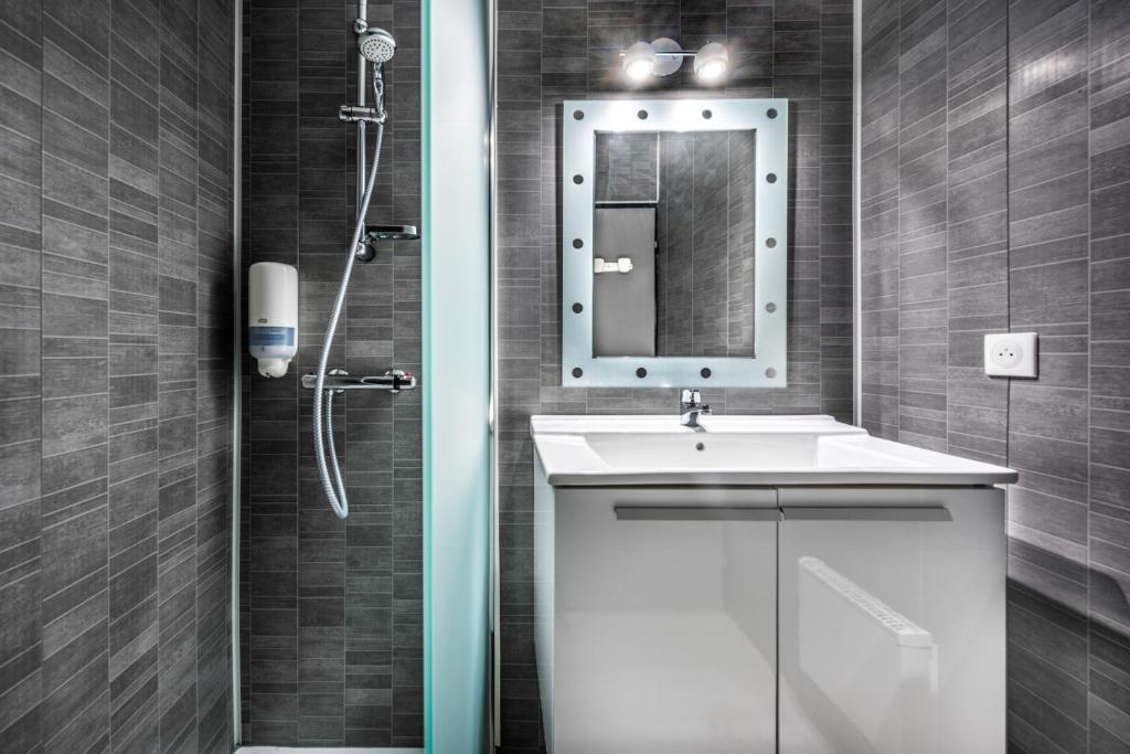 a bathroom with a sink and a shower with a mirror at Le Clos des Bruyères in Vallon-Pont-dʼArc