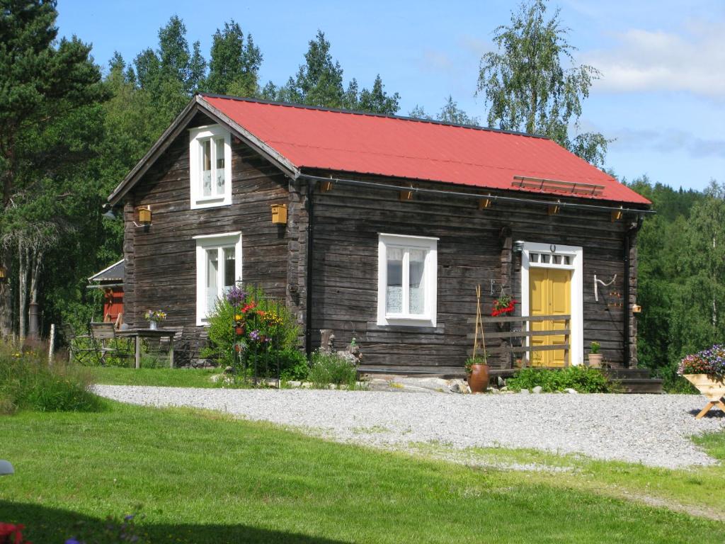 a small log cabin with a red roof at Stuga Lugnvik in Lugnvik