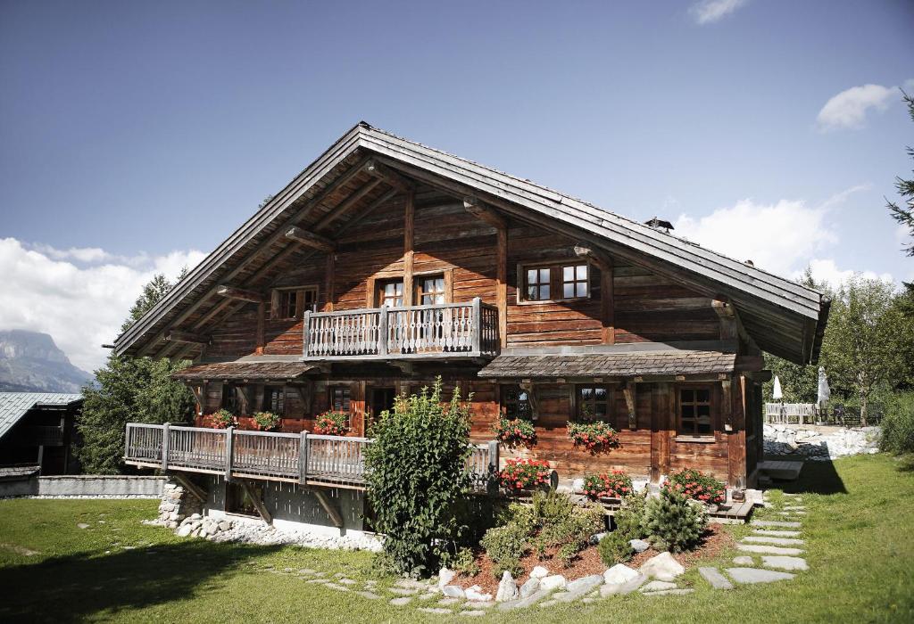 a large wooden house with a porch and a balcony at Chalet Chatel, avec services, Collection Chalets des Fermes - Megève in Megève