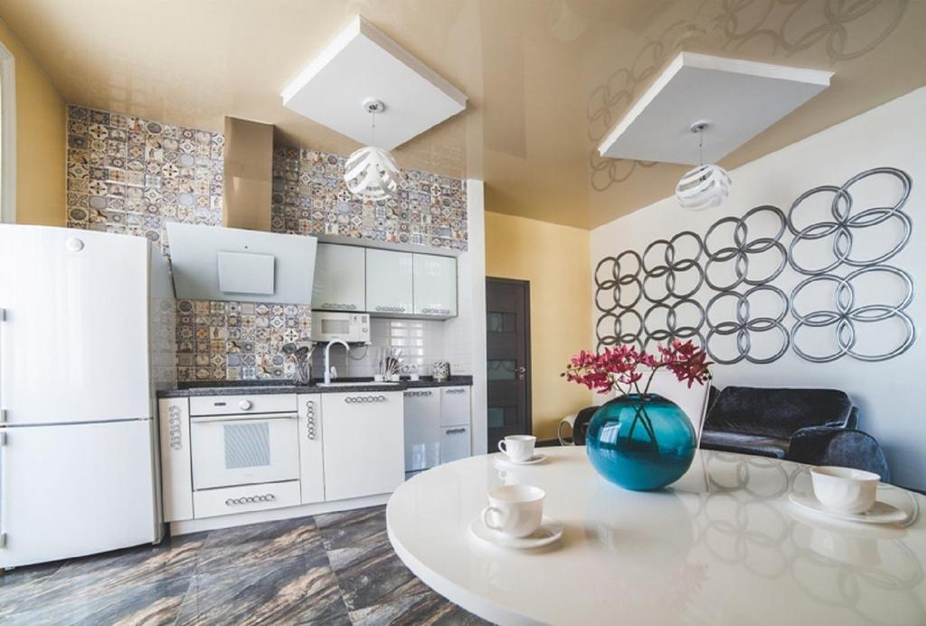 a kitchen with white appliances and a white table at Kapitan Apartments in Odesa