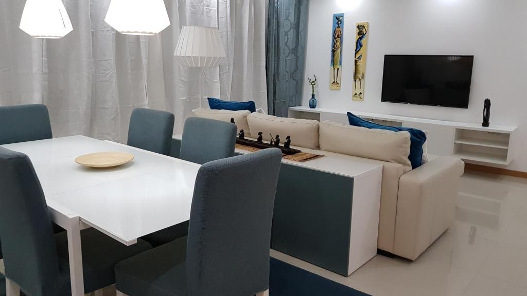 a living room with a table and a couch with a chessboard on it at Elegant Modern Blue Apartment in Praia