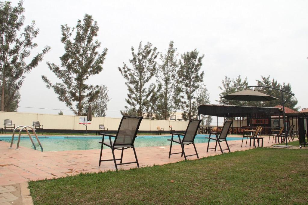 una piscina con sillas y un piano junto a una piscina en Nyagatare Diplomat Hotel, en Nyagatare