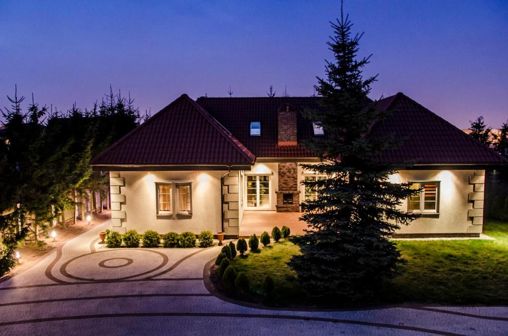 une maison avec un arbre de Noël en face dans l'établissement Villa Hof, à Luboń