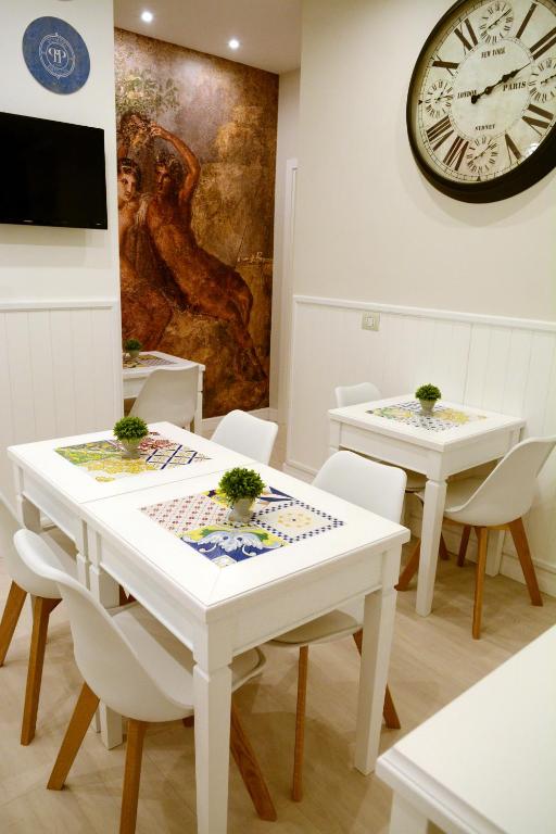 jadalnia z dwoma stołami i zegarem na ścianie w obiekcie B&B Pompei Passion w mieście Pompeje