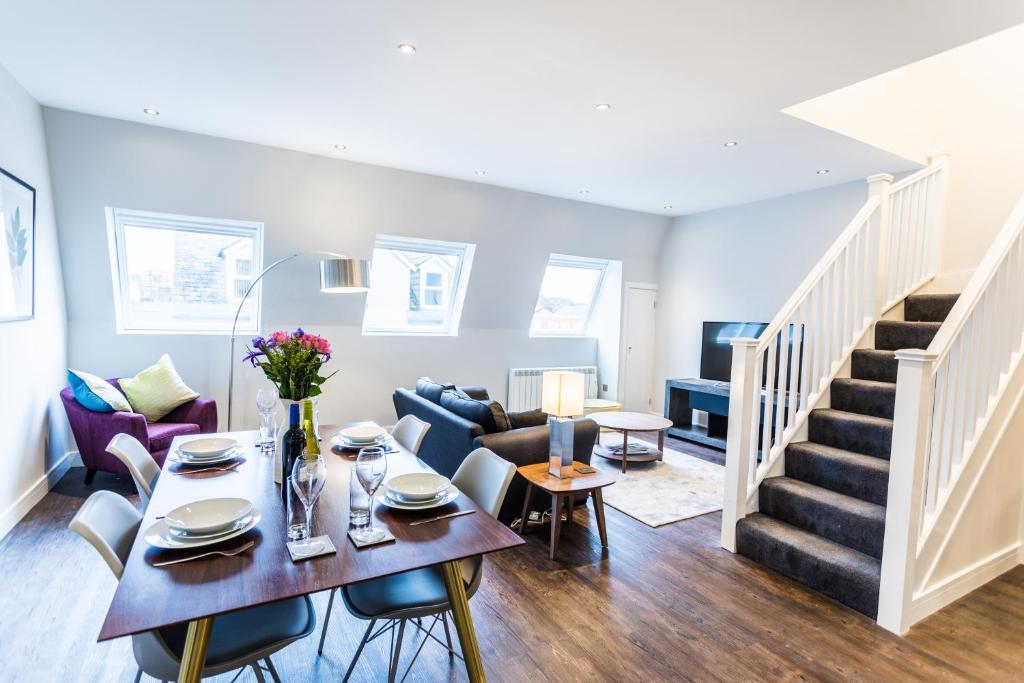 uma sala de estar com uma mesa e um sofá em Suite Life Serviced Apartments - Old Town em Swindon