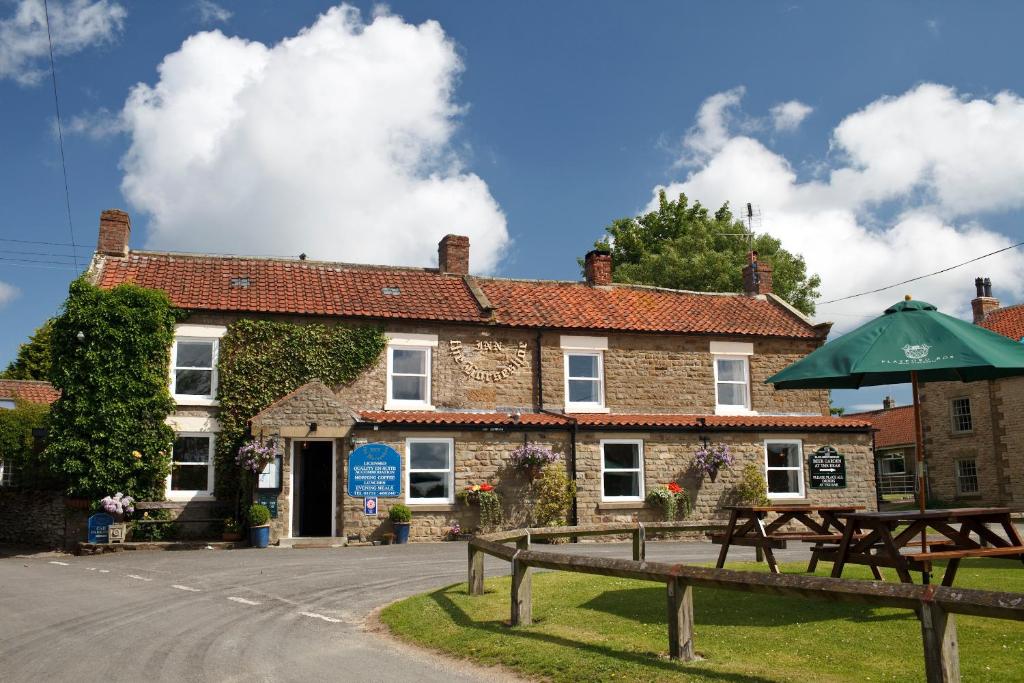 un edificio con una mesa de picnic delante de él en The Horseshoe Country Inn, en Pickering