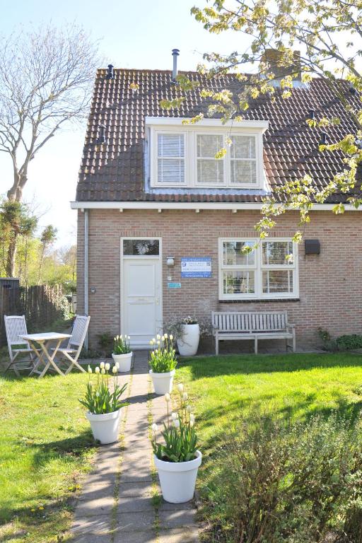 a brick house with a bench in the yard at Vrijvakantiehuis Roosjesweg 1a in Domburg