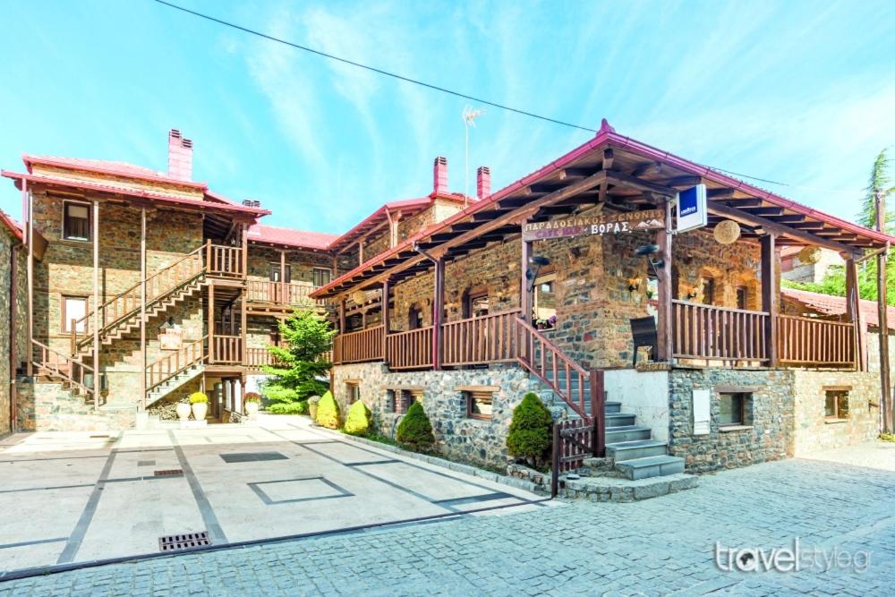 a large brick building with a balcony on it at Hotels Voras in Palaios Agios Athanasios