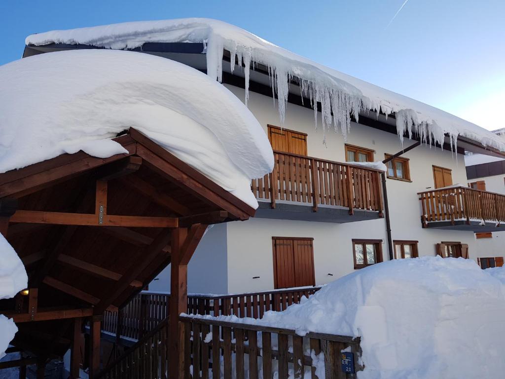 a building covered in snow with icicles on it at Apartment La Gleisa 3 in Sestriere