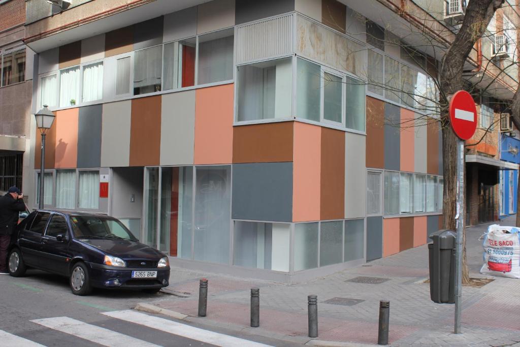 een zwarte auto geparkeerd voor een gebouw bij Apartamentos Funway in Madrid