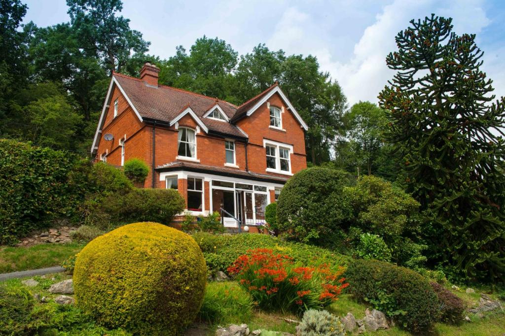a brick house with a garden in front of it at Mynd House in Church Stretton