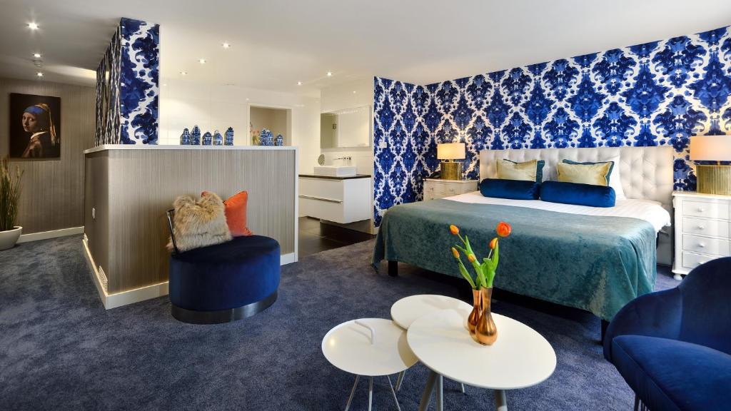 a hotel room with a bed and a couch and tables at Van der Valk Hotel 's-Hertogenbosch – Vught in Den Bosch