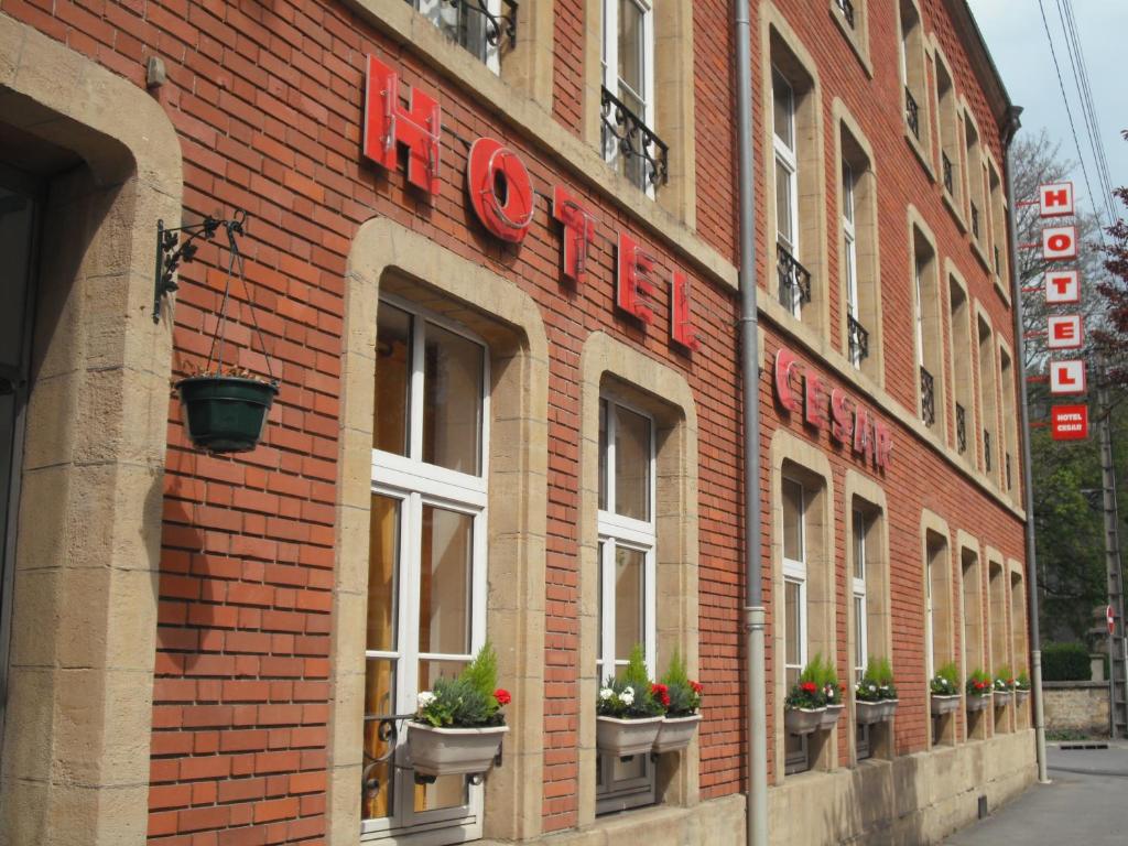 budynek z czerwonej cegły z oknami i roślinami w obiekcie Cesar Hotel w mieście Charleville-Mézières