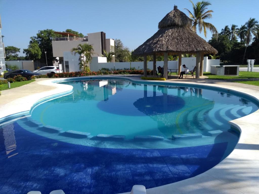 a large blue swimming pool with a gazebo at Departamento Acapulco Diamante in Acapulco