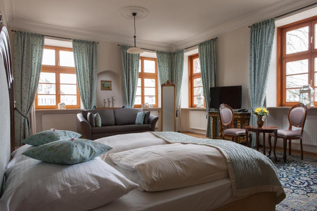 a bedroom with a bed and a couch and windows at Schloss Gerzen in Gerzen