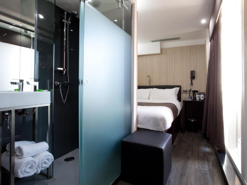 a small bathroom with a bed and a shower at The Z Hotel Soho in London
