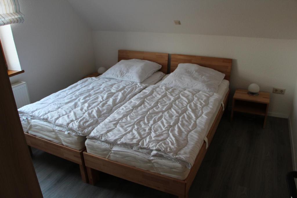 a bedroom with a large bed with white sheets and pillows at Ferienwohnungen Hensel in Minsen