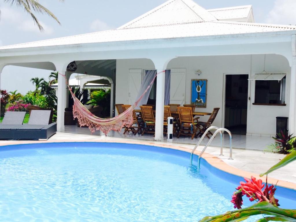 a swimming pool in front of a house at Horizon Karukera in Sainte-Rose