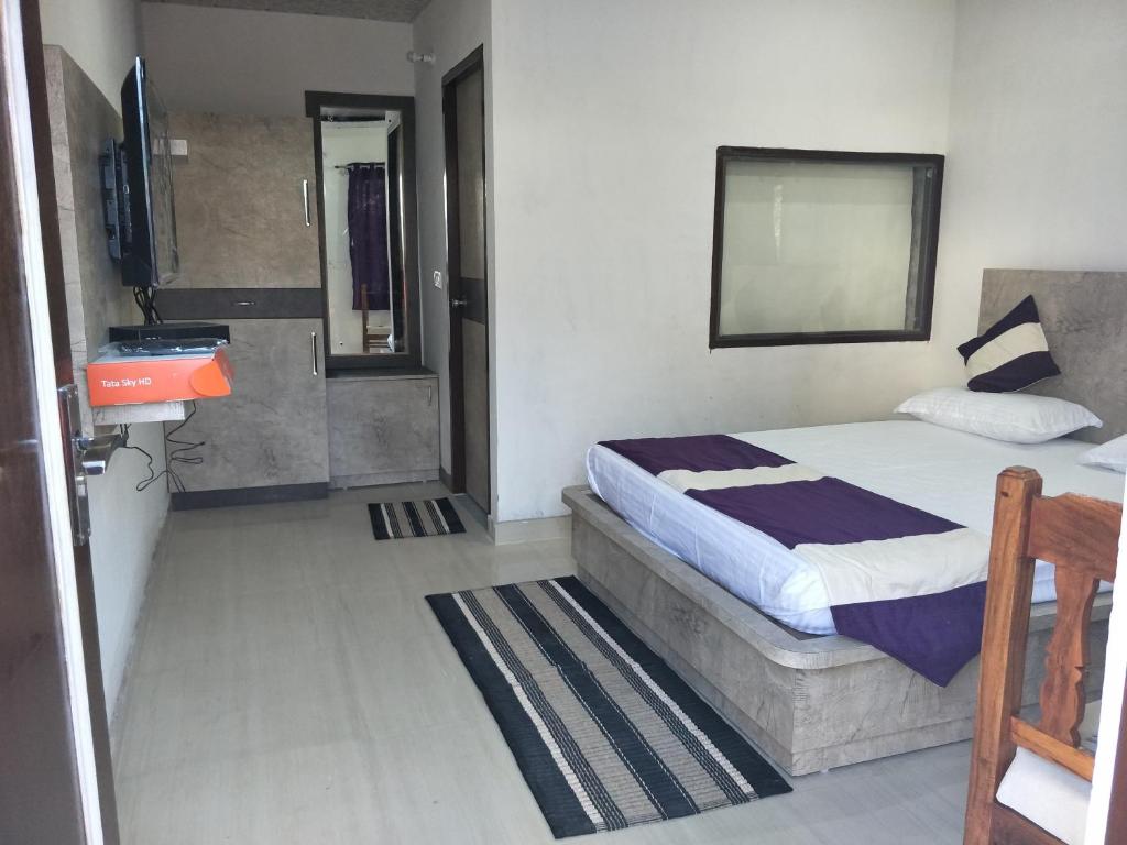 1 dormitorio con cama y espejo en la pared en Rock resort en Dhanaulti