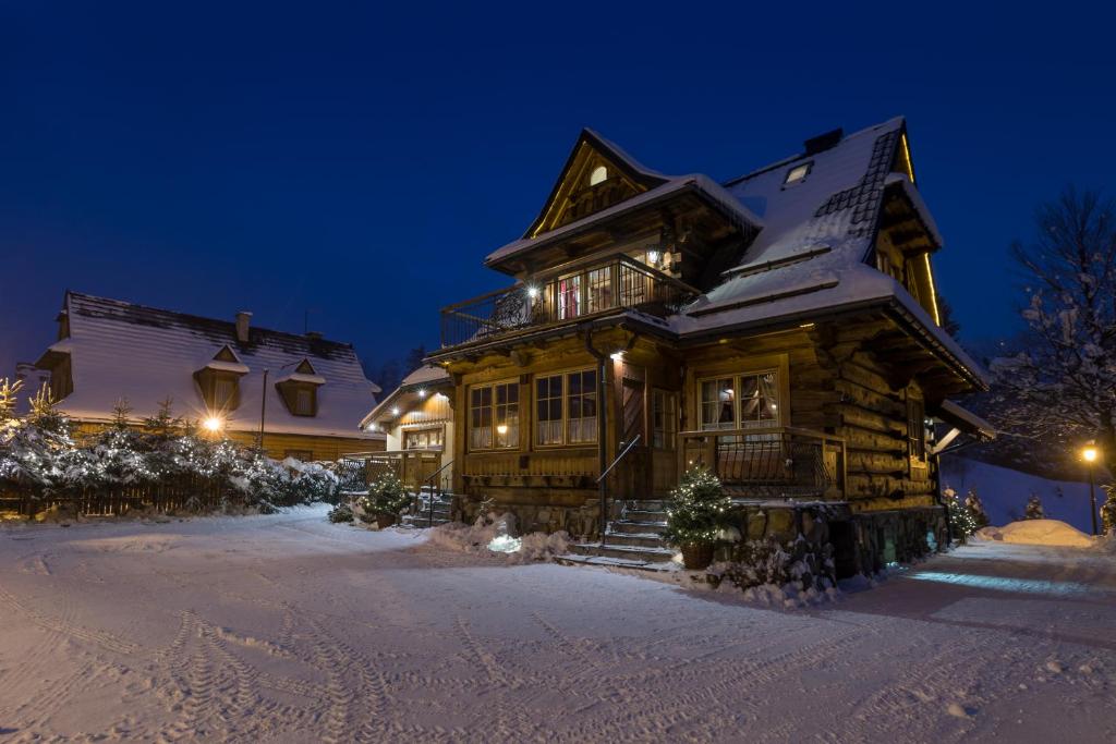 eine Blockhütte im Schnee bei Nacht in der Unterkunft Bambi Cottage in Zakopane