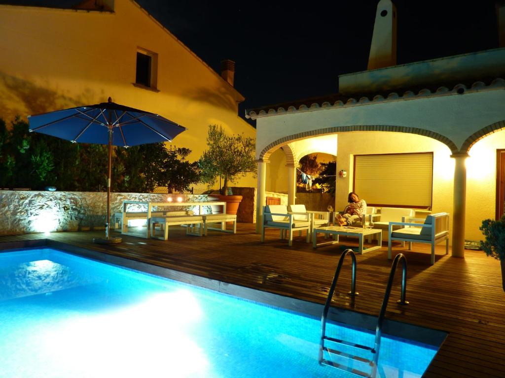 una casa con piscina por la noche en Villa Mas Sopes en Sant Pere Pescador
