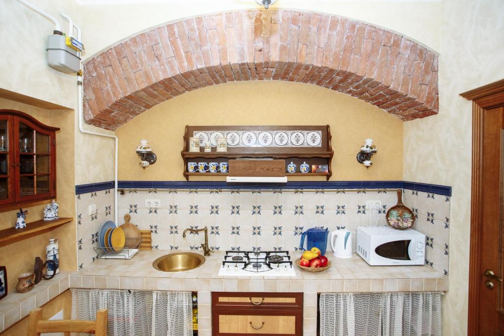 a small kitchen with a sink and a microwave at Halytska in Lviv