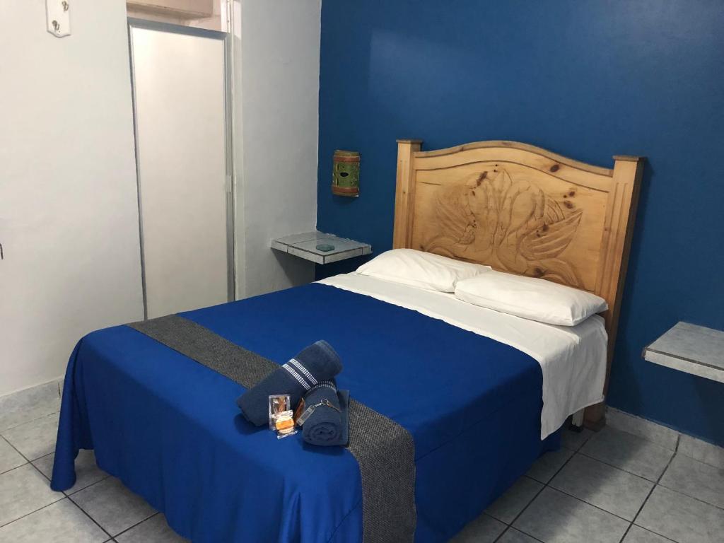 a blue bedroom with a bed with a camera on it at Hotel San Juan in Guadalajara