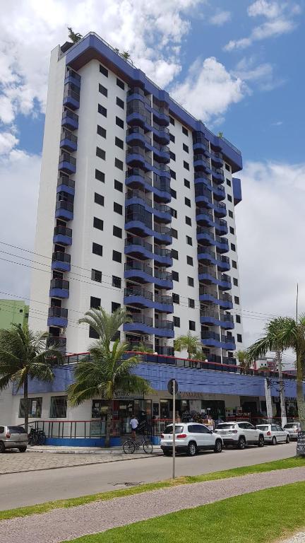 a large building with cars parked in front of it at Caraguá Martins de Sá in Caraguatatuba