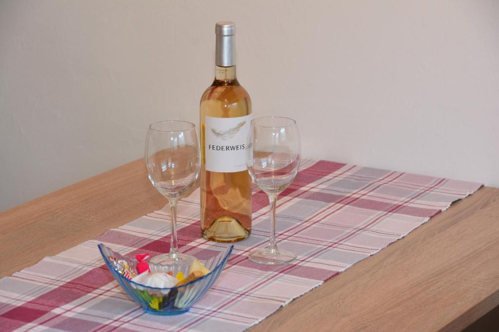 a bottle of wine and two wine glasses on a table at Chasa Val Bella in Samnaun