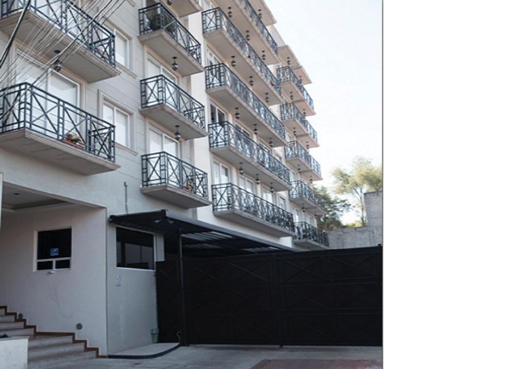 a building with balconies and a black fence in front of it at Habitación en Departamento Coyoacan in Mexico City