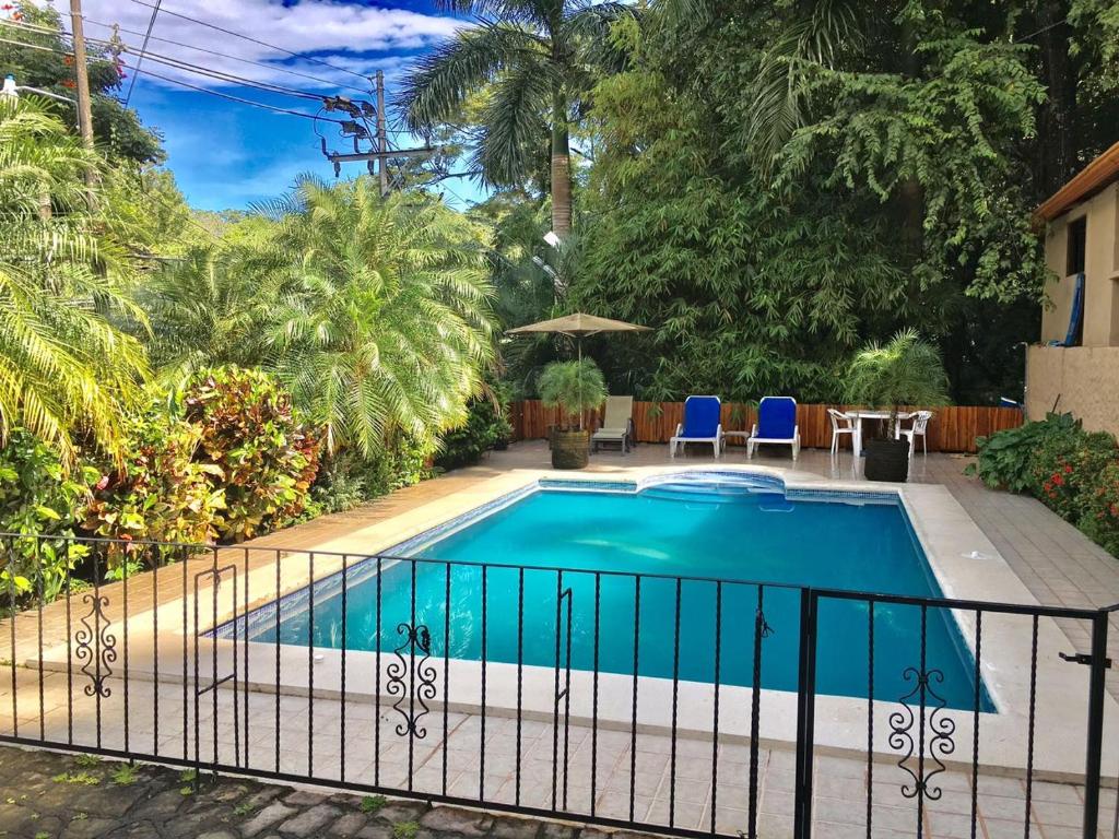 a swimming pool with a fence around it at Hotel Colibri in Manuel Antonio