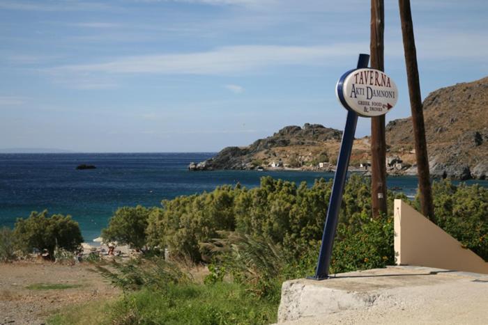 a sign on the side of a beach with the ocean at Akti Damnoni in Damnoni