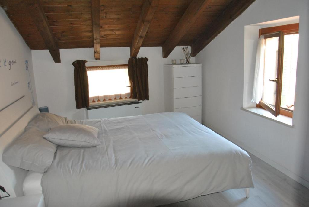 a bedroom with a white bed and two windows at Verona Relais + Private parking in Verona
