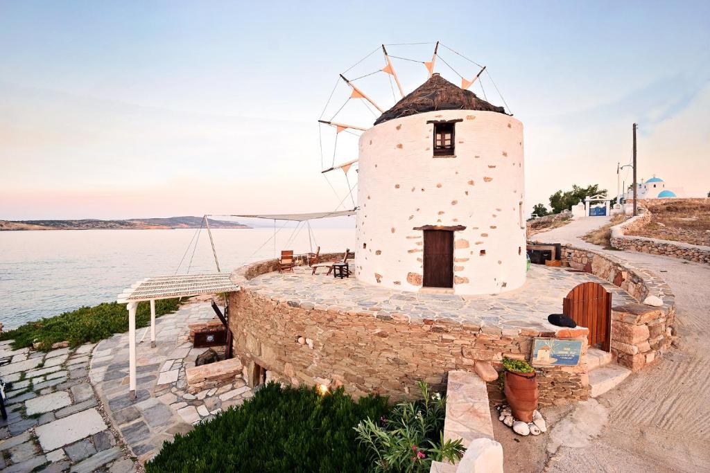 a windmill on the side of a body of water at Windmill Villa in Koufonisia