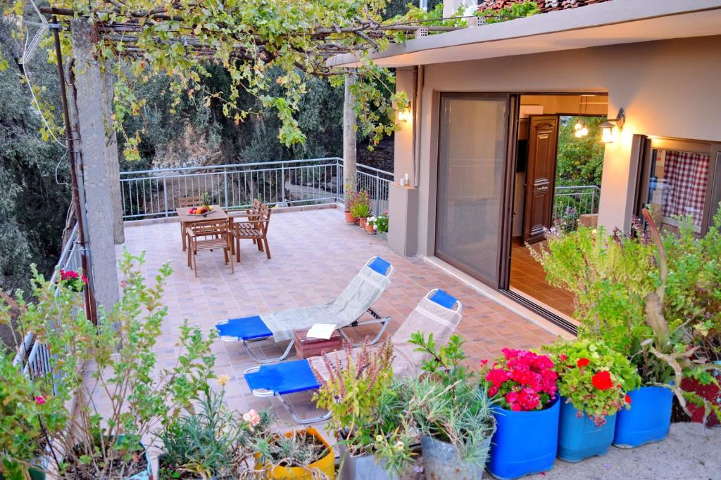 a patio with chairs and a table and some plants at Villa Portreto in Kambanós