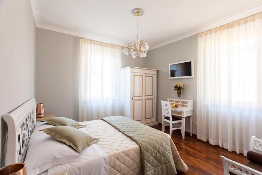 a bedroom with a bed and a desk in it at Il Portico Camere e Caffè - centro Città in Savignano sul Rubicone