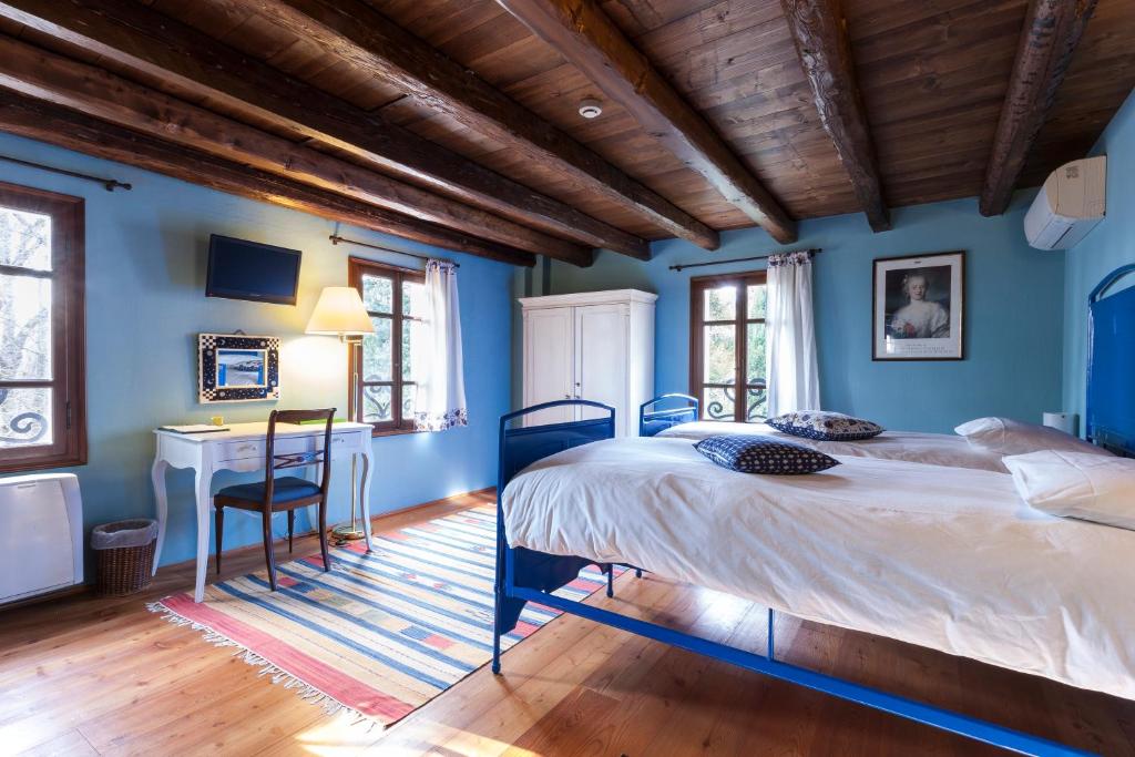 a blue bedroom with a large bed and a desk at Ca' Marsure B&B in Azzano Decimo