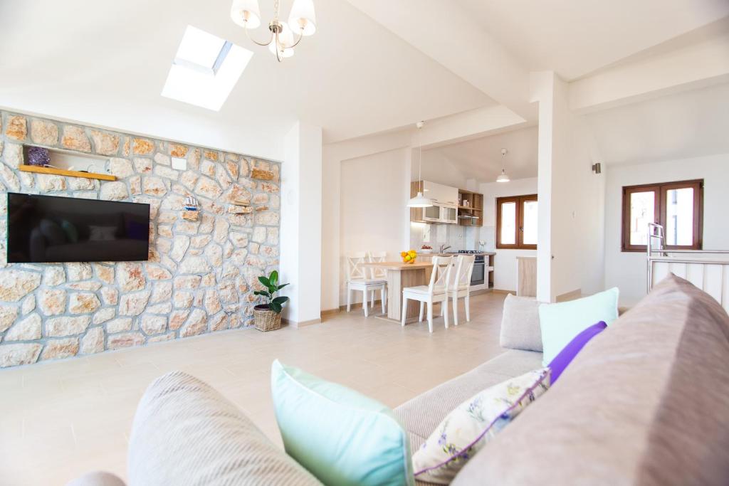 a living room with a couch and a stone wall at Deluxe Villa Nina in Novi Vinodolski